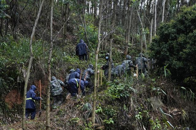 救援人员穿防护服泥泞中搜寻