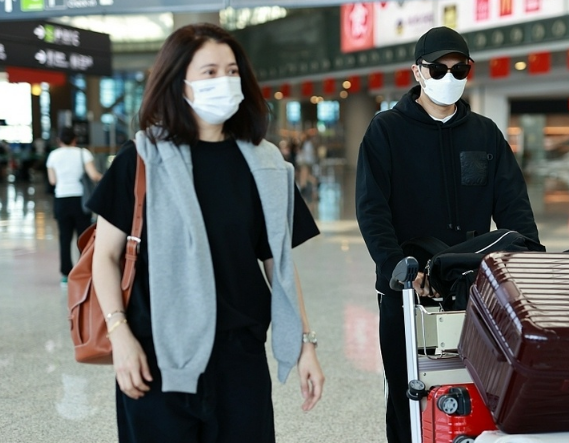 袁咏仪穿羽绒服与张智霖现身机场，大仙冷得穿两件外套，对望好甜