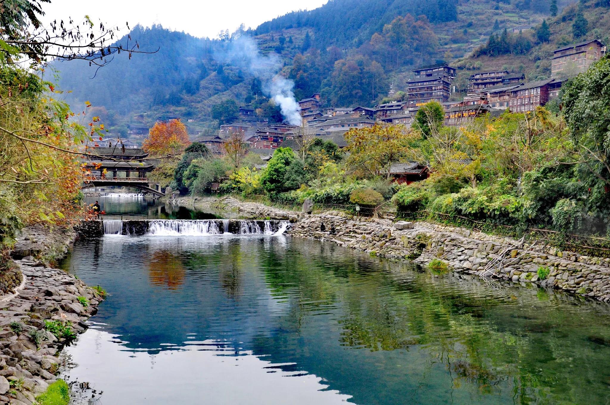 忽见湖边的一间砖瓦房的小烟囱,袅袅升起一缕黑色的炊烟,炊烟升到半空