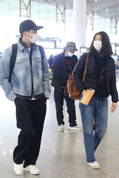 袁咏仪穿羽绒服与张智霖现身机场，大仙冷得穿两件外套，对望好甜