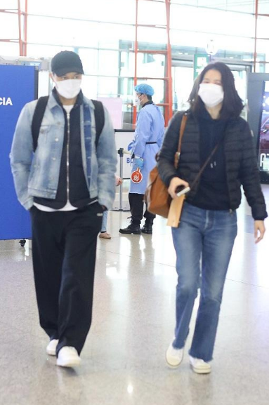 袁咏仪穿羽绒服与张智霖现身机场，大仙冷得穿两件外套，对望好甜