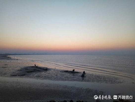 夕阳染红了烟台的海边，余晖布满海面惊艳游人