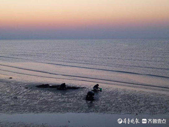 夕阳染红了烟台的海边，余晖布满海面惊艳游人
