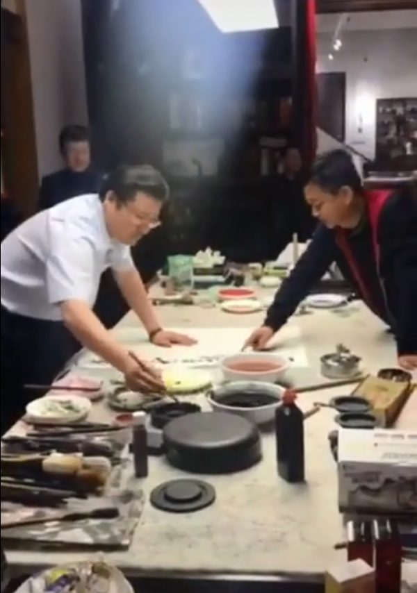 56岁朱军现身聚会，大佬聊天他指点人书法，一幅画曾卖130万
