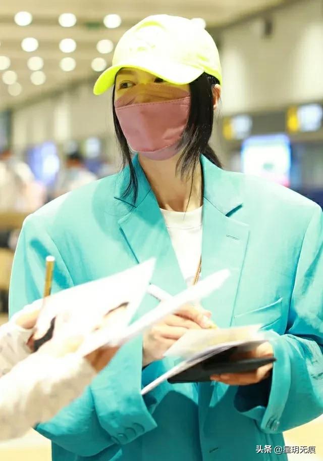 谭维维戴荧光色棒球帽穿孔雀蓝外套出行 艳丽惹眼星范足