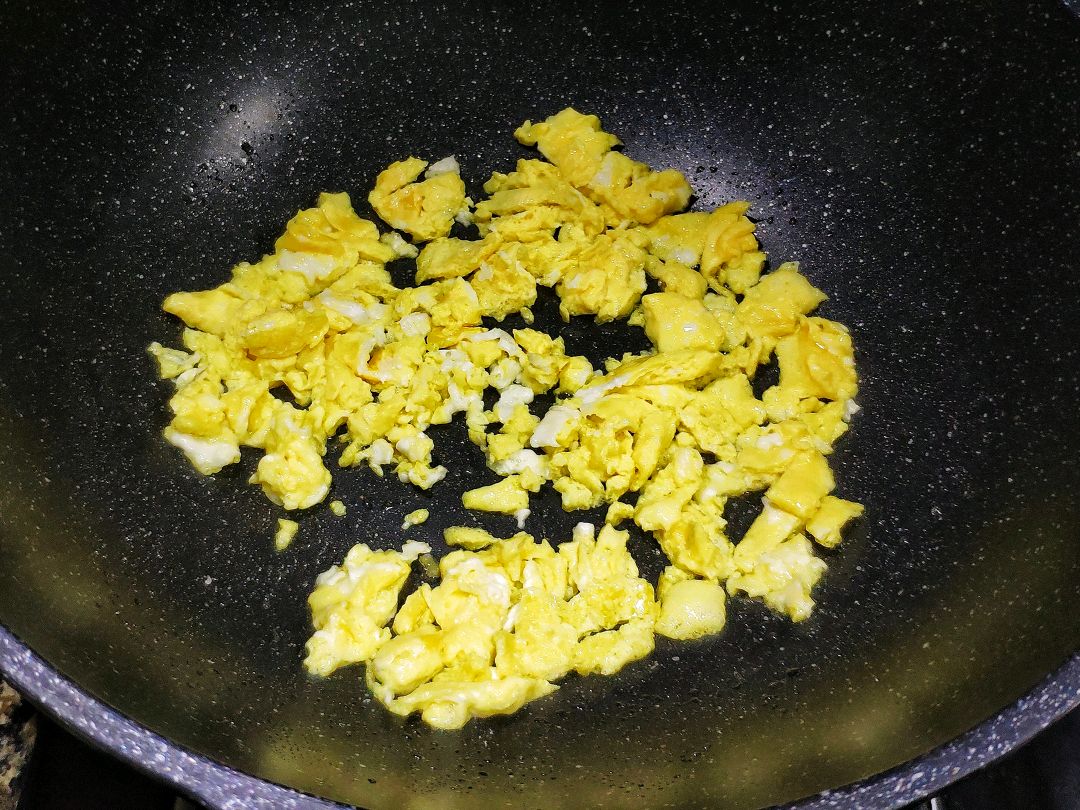 步骤5,等蛋液煎到凝固之后,再用铲子把鸡蛋饼一点一点炒碎,准备出锅