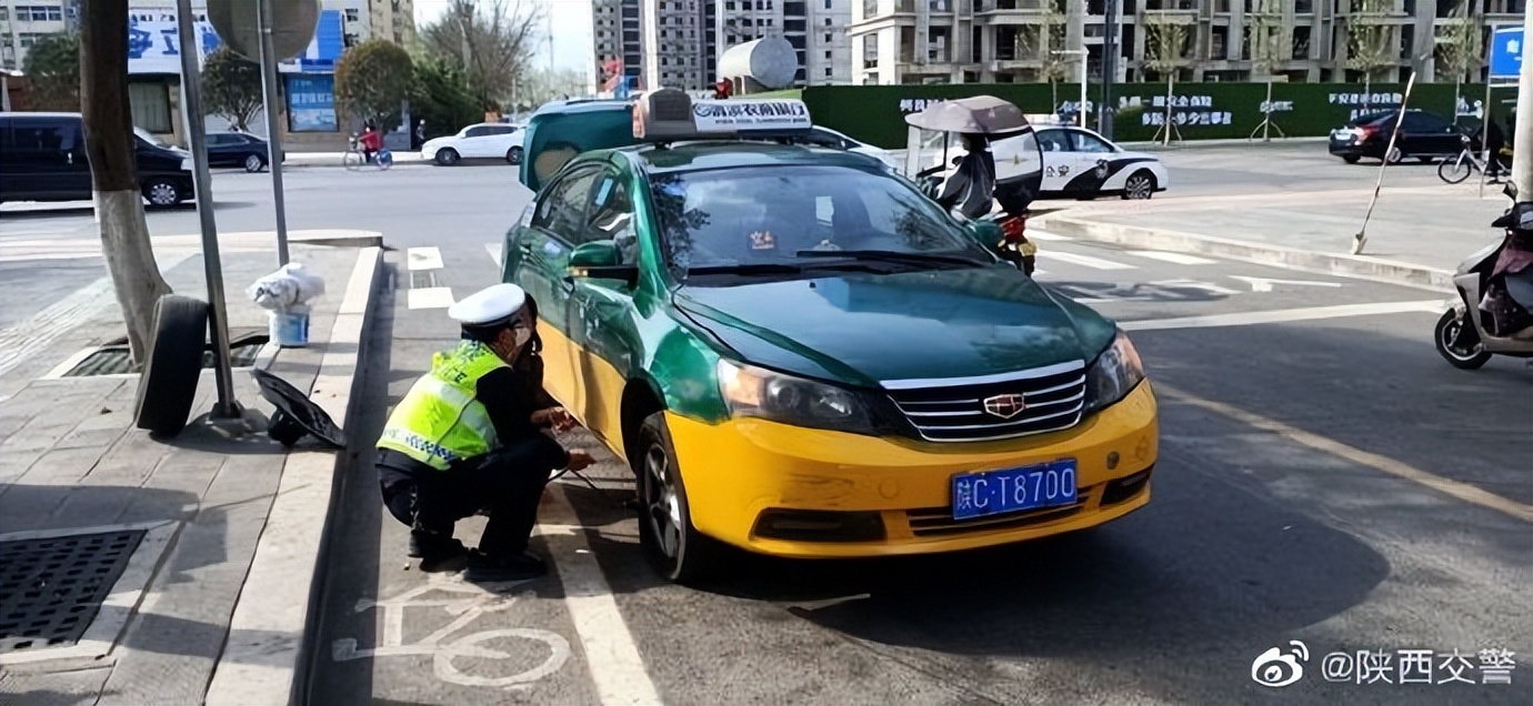出租车路中爆胎，交警化身“修车工”