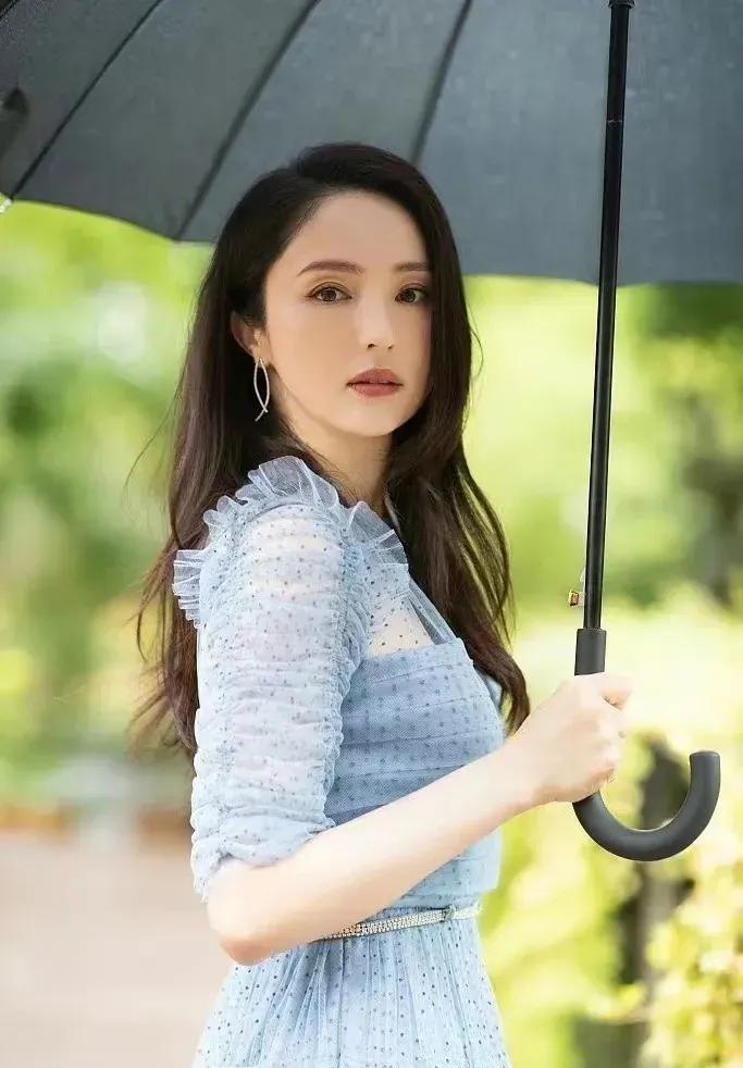 董璇一袭蓝色长裙，一把墨色雨伞，优雅大方，温婉动人