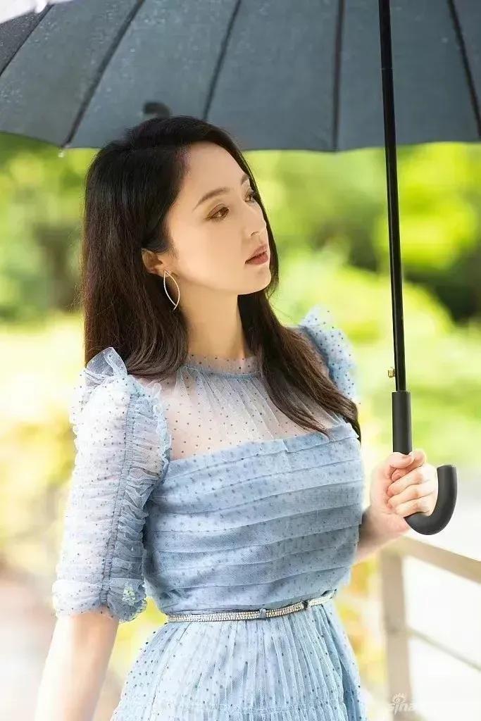 董璇一袭蓝色长裙，一把墨色雨伞，优雅大方，温婉动人