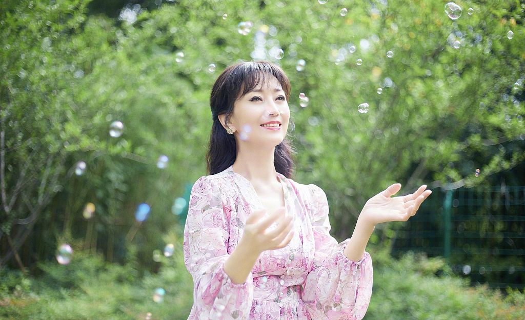赵雅芝着粉色雪纺碎花裙户外玩耍 五彩泡泡营造梦幻氛围
