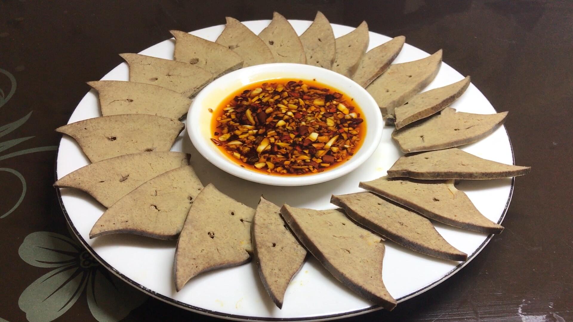 三,盐水猪肝表面铺上蒜蓉辣椒,再淋上料汁,美味的蒜蓉秋葵就做好了.